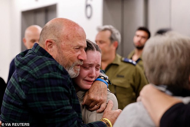 Agam Goldstein-Almog, 17, (pictured, center) is embraced by loved ones in Israel last night after spending weeks as a hostage