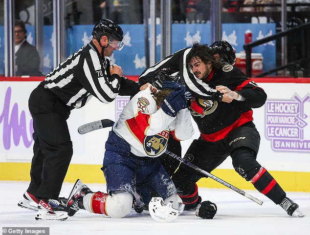 Florida's Matthew Tkachuk (in white) and Ottawa's Zack MacEwen are pulled apart