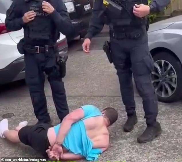 It also shows a man pinned to the ground before getting up and then falling over again as police try to restrain him