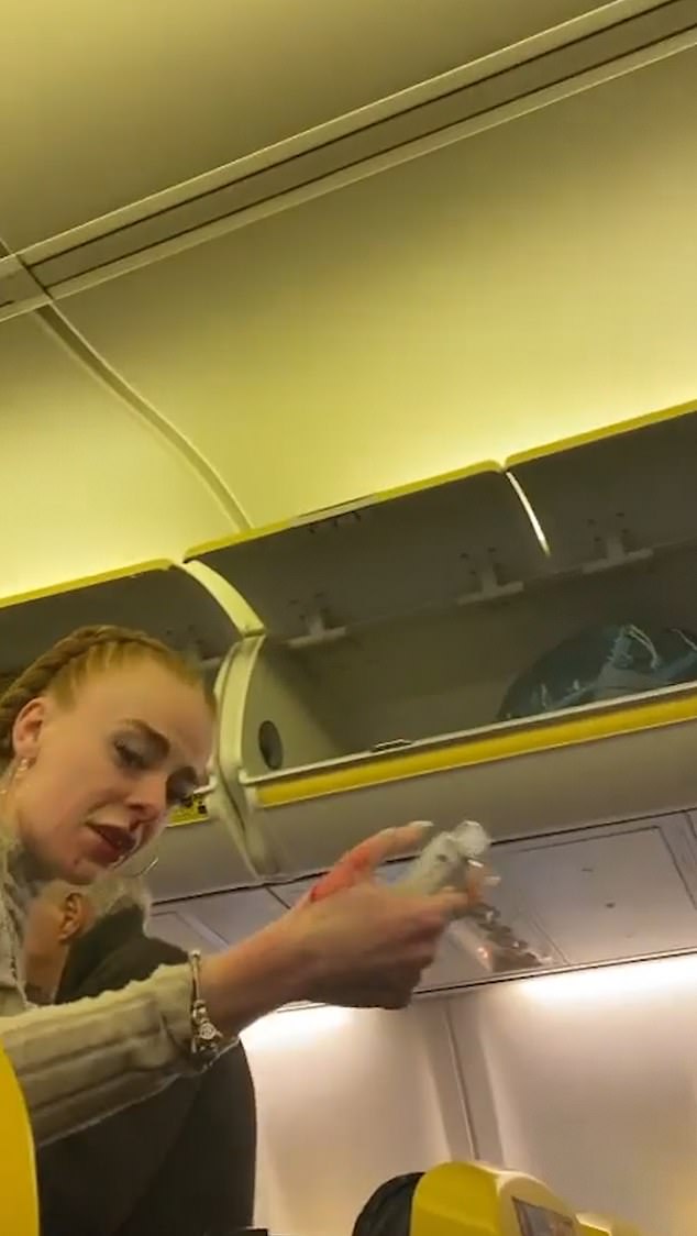 Blood from the excited passenger's nose is wiped on her hand as she looks at the camera