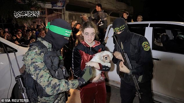 A fifth group of hostages was released on Tuesday.  Pictured: A teenage hostage holds a dog as she is flanked by Hamas gunmen during her release