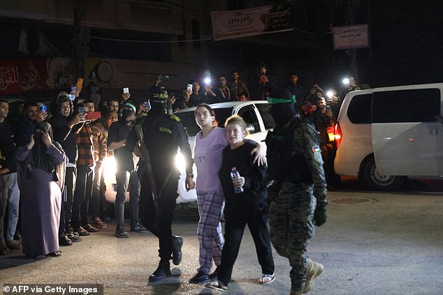 Hamas fighters escort newly released hostages before handing them over to the Red Cross in Rafah