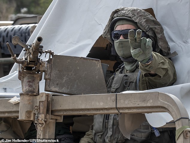 An Israeli infantry soldier gestures to a Humvee as a convoy heads toward the Gaza Strip on Tuesday