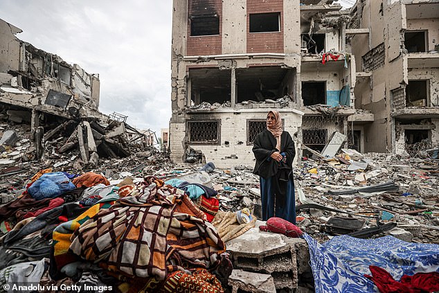 A Palestinian woman walks among the rubble in the Juhor ad-Dik residential area in the Gaza Strip on Tuesday