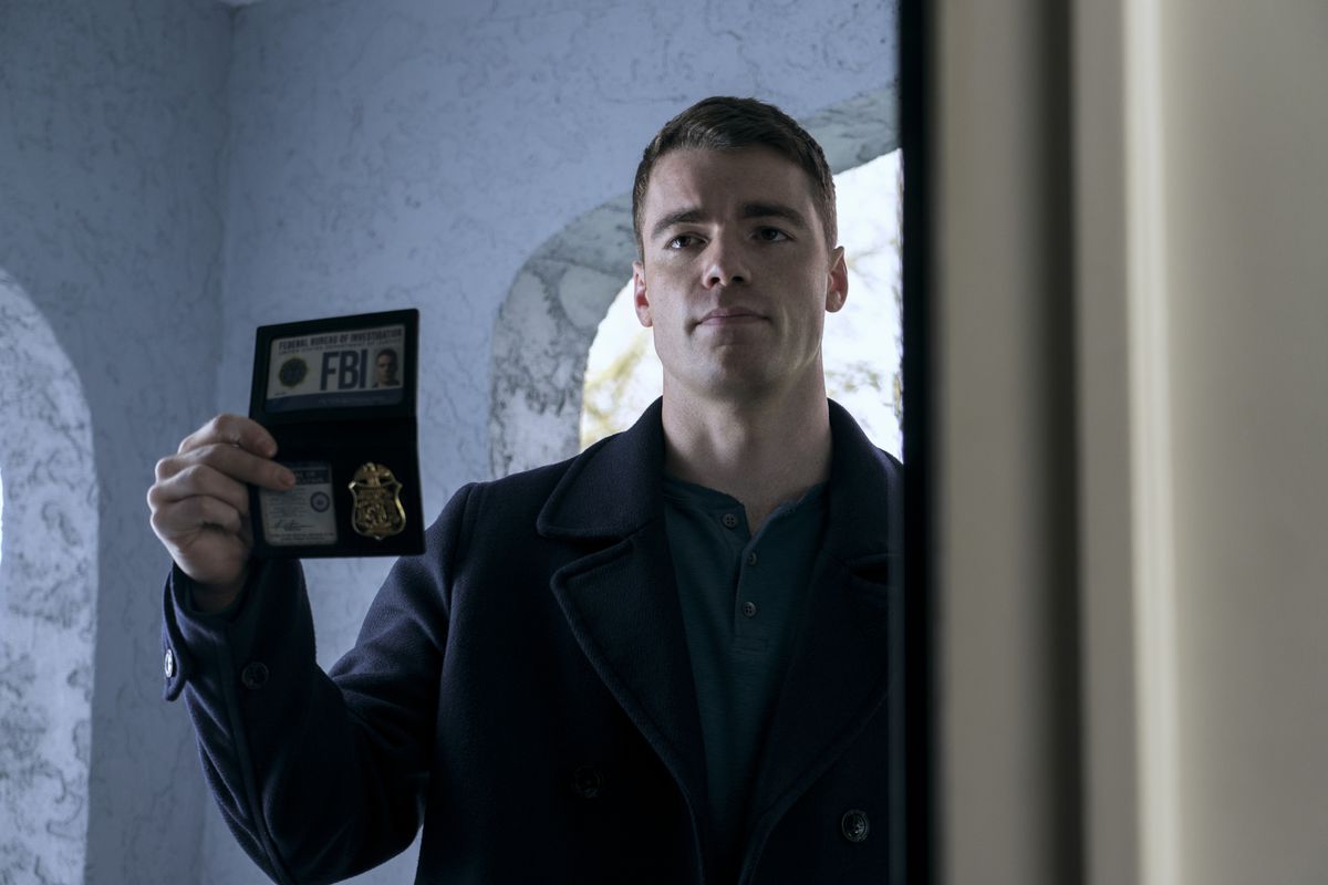 Gabriel Basso holds up his FBI badge in The Night Agent