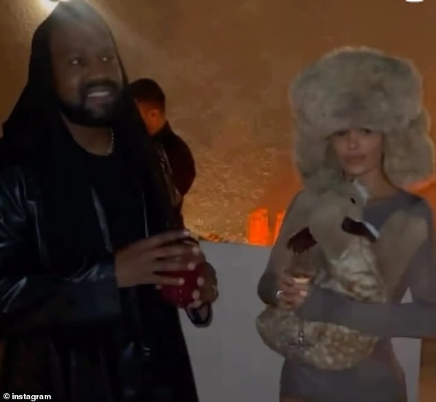 Videos show the 'fashionable' duo dressed in contrasting outfits.  While West continued to wear an all-black look, Censori was seen in a short, neutral-colored dress with a trooper-style hat and an animal-shaped pillow.