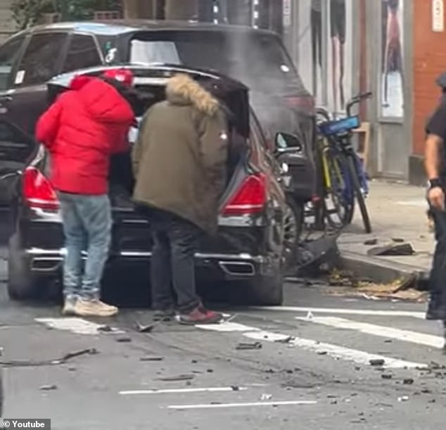 Passersby inspect damage at the scene of Sunday's accident at the South West Corner of Broadway and West 55th Street