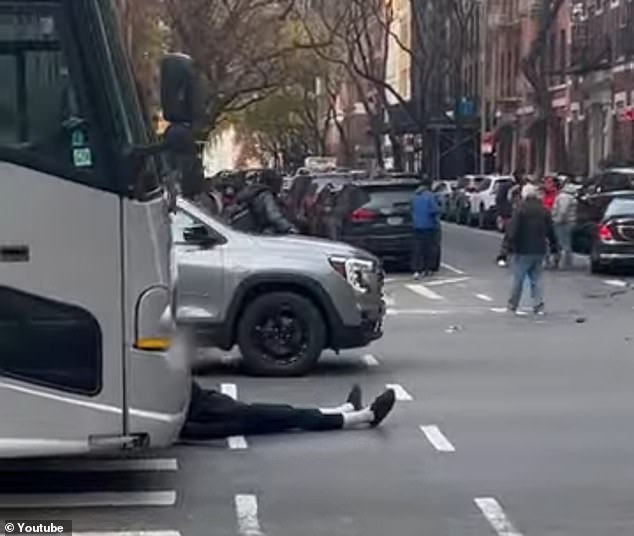 Brooks appears to remove himself from the crashed car and walk unsteadily into the street before sitting down in front of a bus on the road