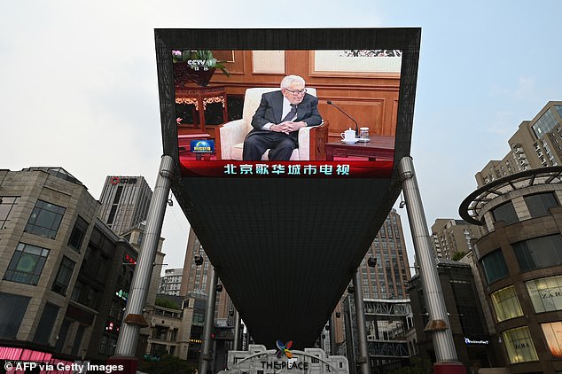 A giant screen outside a shopping mall shows coverage of former US Secretary of State Henry Kissinger during his meeting with Chinese President Xi Jinping in Beijing on July 20, 2023