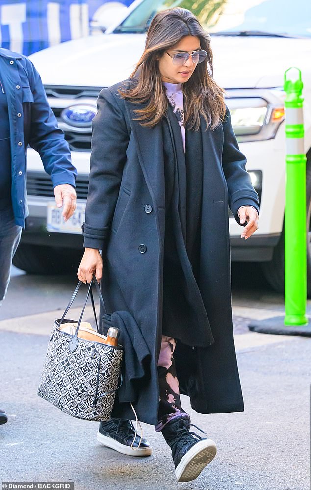 Chopra tucked the bottom of her pants into a pair of high-top leather sneakers and wore a hefty black trench coat