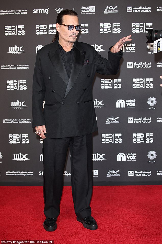 Johnny looked serious as he struck a series of poses on the red carpet