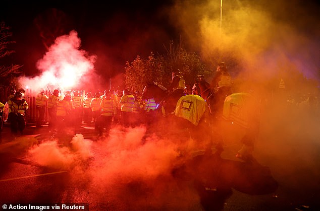 Legia fans let off flares as they were trapped by the wall of police officers