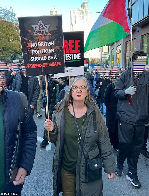 Kate Varnfield, 66, was pictured at this weekend's London rally holding a sign with the Star of David entangled in the Nazi swastika above the words: 'No British politician should be a 'friend of Israel'''