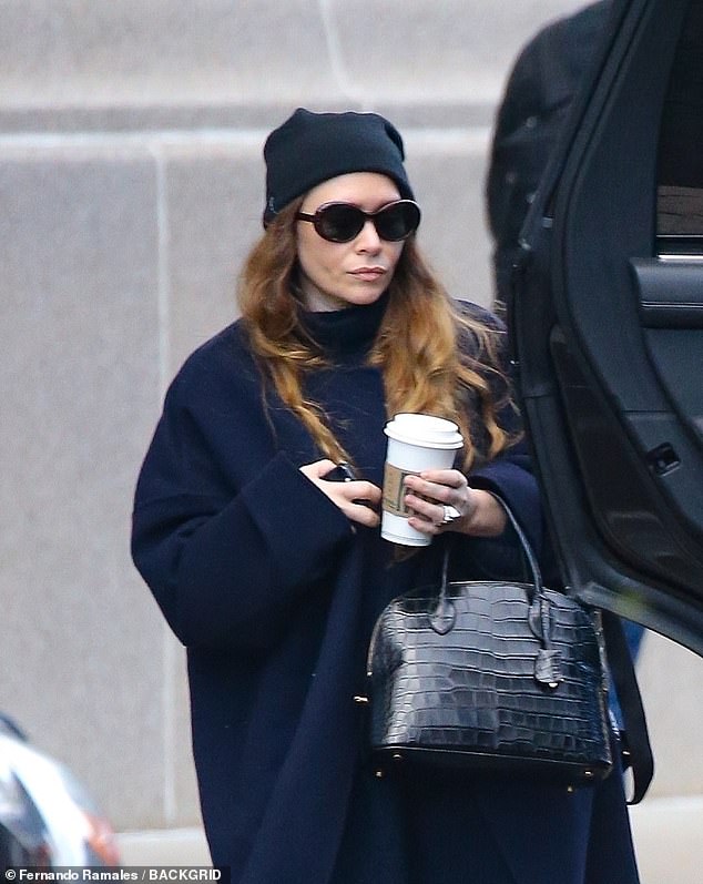 Accessories: The 37-year-old former actress – whose younger sister is Elizabeth Olsen – wore a messy black beanie and large, dark, oval sunglasses