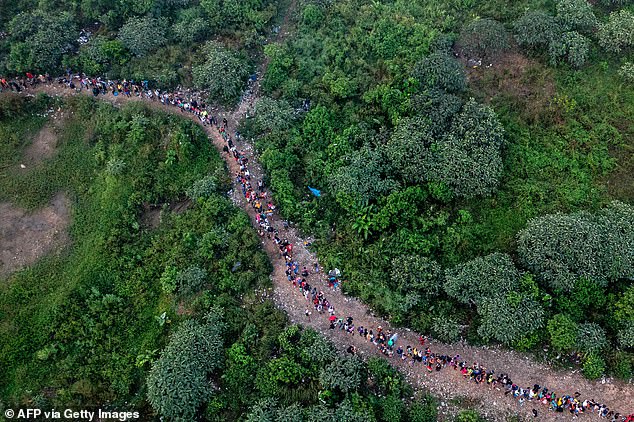 Aerial view of migrants walking through the jungle near the village of Bajo Chiquito, the first border checkpoint of Panama's Darien Province, on September 22, 2023. The clandestine journey through the Darien Gap usually takes five or six days, at the mercy of all kinds of bad weather