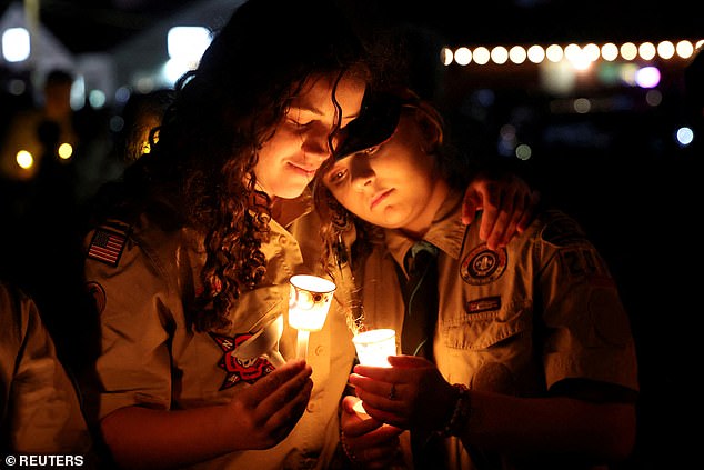 Mourners hold candles during a vigil for the victims of the Lewiston mass shooting as officials answer questions about the missed opportunities they had to stop a killer