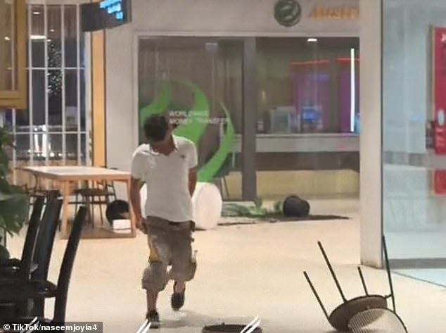 The 23-year-old was seen throwing tables, chairs and potted plants at the shopping center on Jacobs Street in Bankstown at around 9.30pm on Friday.