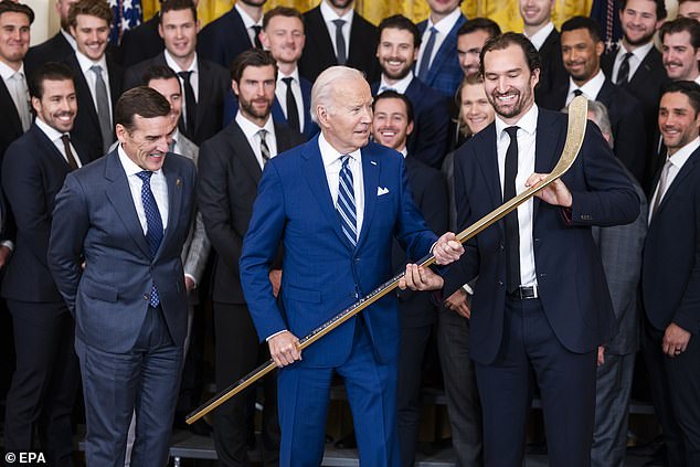 President Joe Biden receives a gold hockey stick from the Vegas Golden Knights