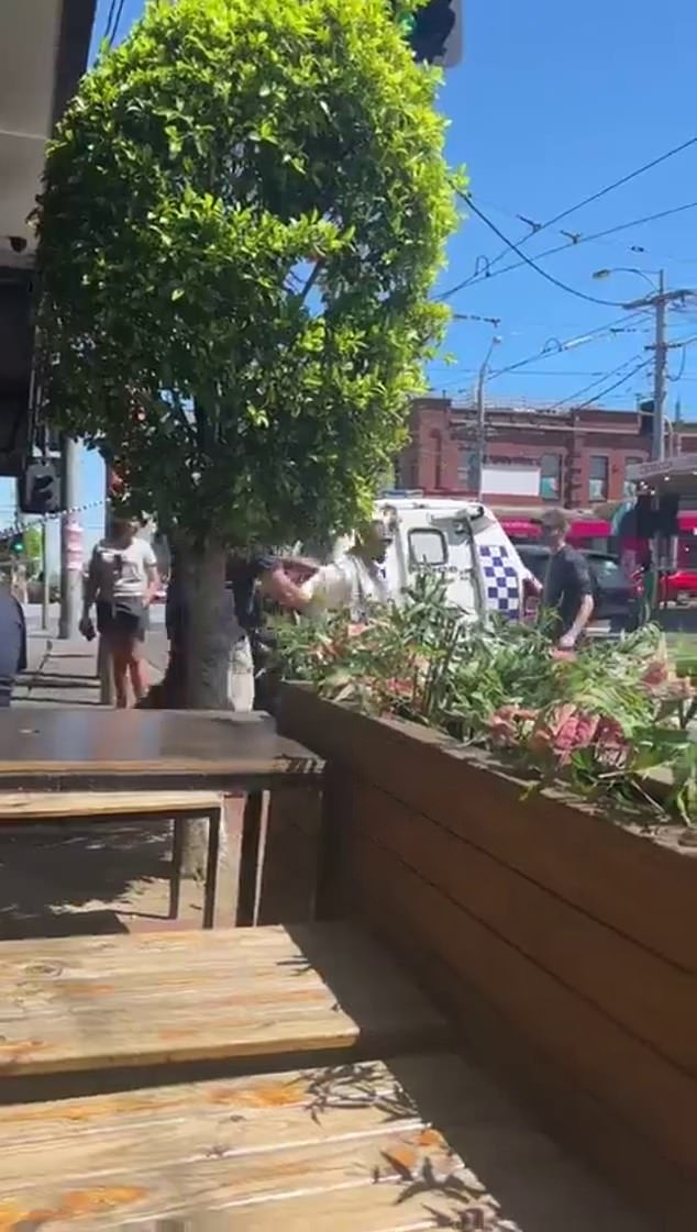 A man is led away by police on Friday afternoon after tense scenes on the streets of Melbourne.  Several people arrested to 'keep the peace'