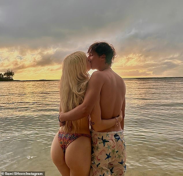 The media personality showed off her toned physique in a colorful two-piece swimsuit as she cozied up next to her boyfriend, who lovingly wrapped his arm around her shoulders.