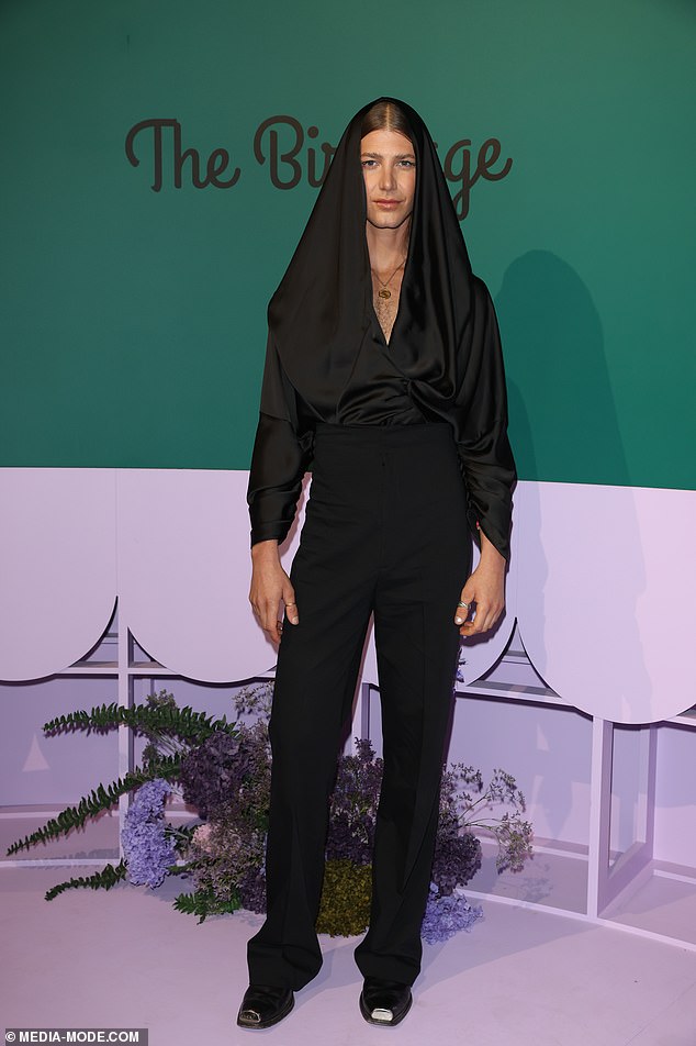 Christian Wilkins showed off his quirky style as he arrived to the star-studded event in black trousers and a layered top wrapped around his hair