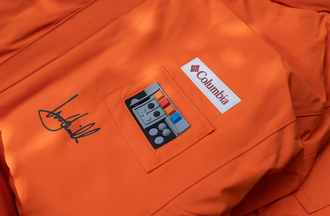 A close-up of Mark Hammill's signature on an orange Columbia jacket