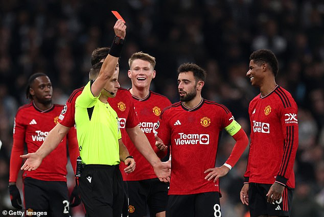 Fernandes is seen interacting with the referee after showing Marcus Rashford (right) a red card