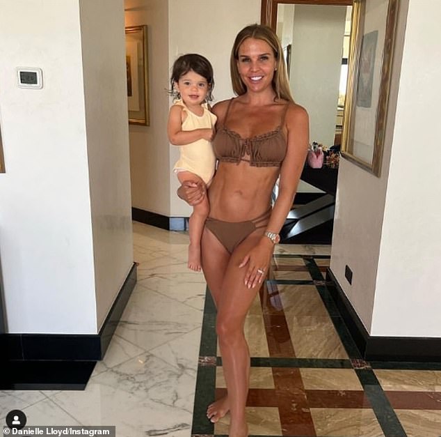 Stunning: Danielle Lloyd looked sensational on Thursday as she shared a new photo in a brown bikini that showed off her washboard abs and long legs as she cradled her daughter Autumn, two