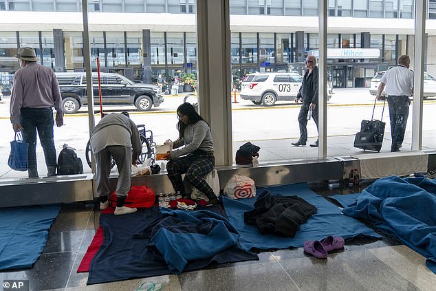 Migrants sleep in a makeshift shelter at Chicago's O'Hare International Airport.  Chicago Mayor Brandon Johnson is one of five Democrats who have written to Biden for help