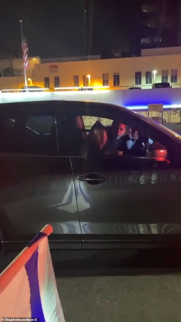 The clip shows Ferrer Van Ginkel reaching her hand out the window while giving the Hitler salute as protesters waving Israeli flags repeatedly shout, 