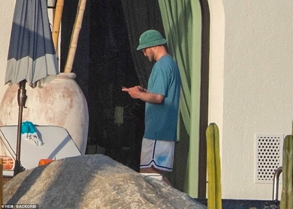 Casual: Meanwhile, Timberlake wore a baggy T-shirt, a green bucket hat and white shorts with navy blue racing stripes down the sides