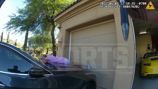 In this clip, Bidwill's wife is seen lying on the hood of the vehicle, parked face down in the driveway of her home, with her head to the side and her eyes closed.