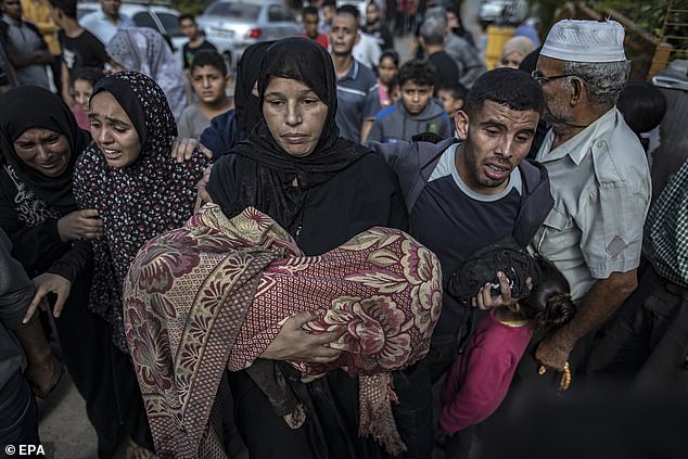 A woman carries the body of her child, killed in an airstrike on a house in the Khan Younis refugee camp, southern Gaza Strip, November 8, 2023