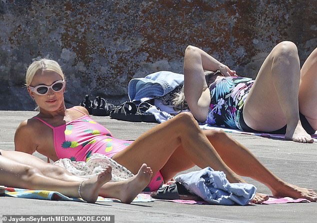 The blonde beauty smiled flirtatiously as she stretched her body out under the sun and hid her eyes behind a pair of pink Christian Dior sunglasses.