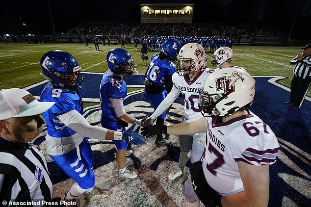 Lewiston High School players greet Edward Little in the first game since the Oct. 25 shooting