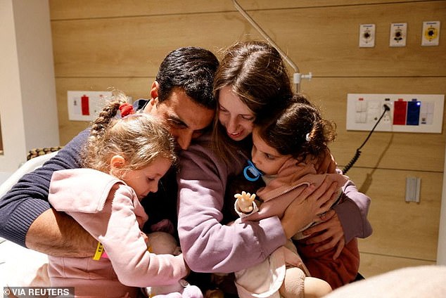 Aviv Asher, 2.5 years old, her sister Raz Asher, 4.5 years old, and mother Doron, react as they meet Yoni, Raz and Aviv's father and Doron's husband, after returning to Israel to the designated complex in the Schneider Children's Medical Center, during a temporary ceasefire between Hamas and Israel, in Petah Tikva, Israel, in this handout photo released on November 25, 2023