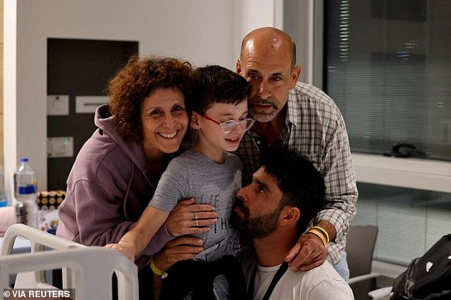 Ohad Munder, 9-year-old, reacts as he meets his relatives after returning to Israel to the designated complex at the Schneider Children's Medical Center, during a temporary ceasefire between Hamas and Israel, in Petah Tikva, Israel