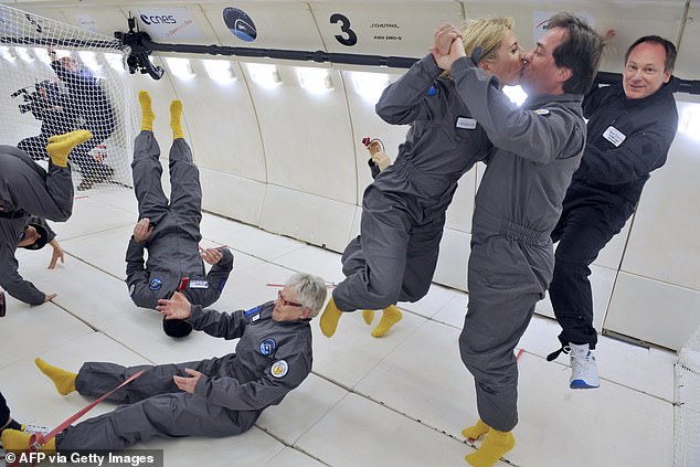 Passengers kiss on a flight that simulates weightlessness in space.  Intimacy in zero gravity is just one of the challenges of extraterrestrial reproduction