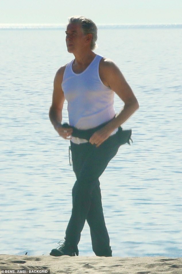 The man with the golden weapons!  Pierce Brosnan put on his own gun show on Tuesday while enjoying a beach day in Malibu