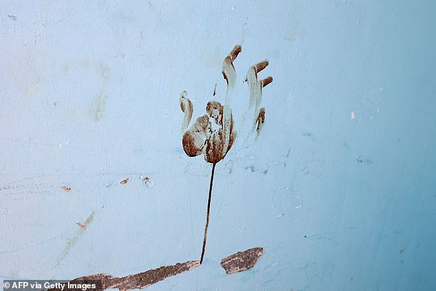 A photo taken in a house in Kibbutz Nir Oz on October 31 shows a bloody handprint on the wall after the October 7 attack