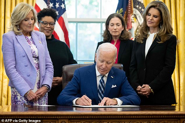 President Joe Biden signs a presidential memorandum establishing the first-ever White House Initiative on Women's Health Research, in the Oval Office with (left to right) First Lady Jill Biden, deputy director of the Office of Management and Budget Shalanda Young, director of the White House Gender Policy Council, Jen Klein, and Maria Shriver, founder of the Women's Alzheimer's Movement
