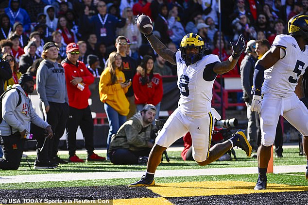 Michigan's Derrick Moore (8) celebrates after returning a fumble for a touchdown