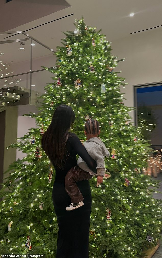 'Tis the season: Kendall wasted little time getting into the holiday spirit, sharing two photos of herself holding Aire in front of the huge Christmas tree