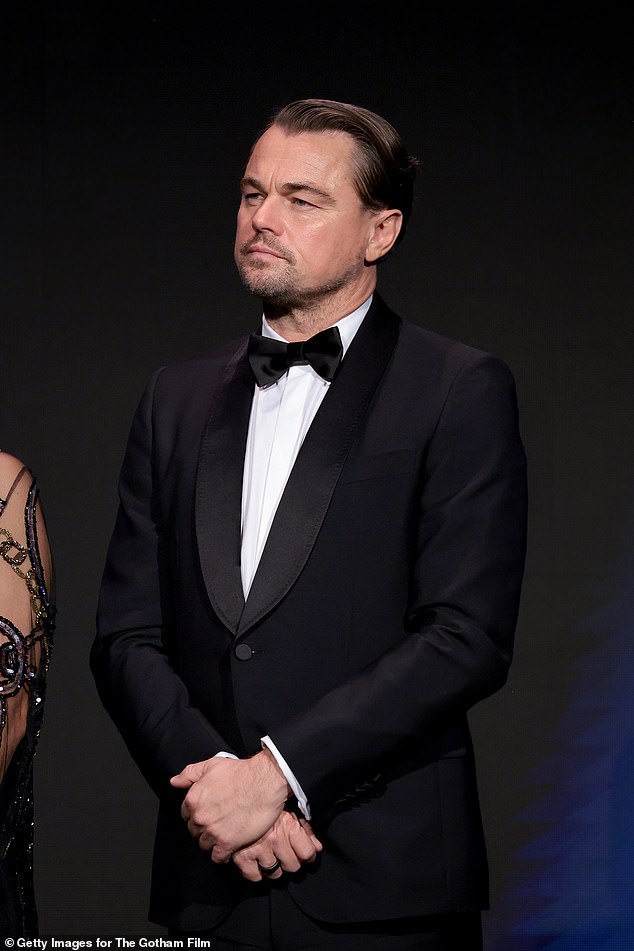 On stage: DiCaprio seen on stage listening to Robert De Niro's speech