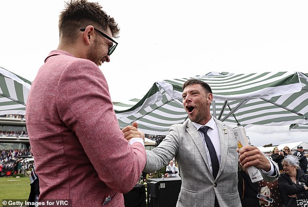 Two lucky punters are pictured at Flemington during last year's Cup.  Follow Daily Mail Australia's guide to punting and you can celebrate like they do on Tuesday afternoon