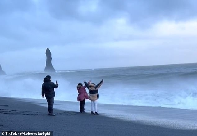 They throw their arms in the air as the next wave starts to roll in, but they were forced to run away quickly after it accelerated and flooded the entire beach.