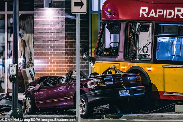 A red sedan southbound on 5th Avenue in Seattle collided with a bus traveling eastbound on Battery Street.  The collision caused the bus to leave the roadway, where it crashed and killed a woman