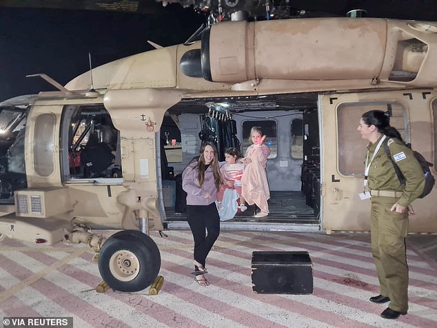 Aviv Asher, 2.5 years old, her sister Raz Asher, 4.5 years old, and mother Doron, react as they step out of an Israeli military helicopter shortly after arriving in Israel on November 24.