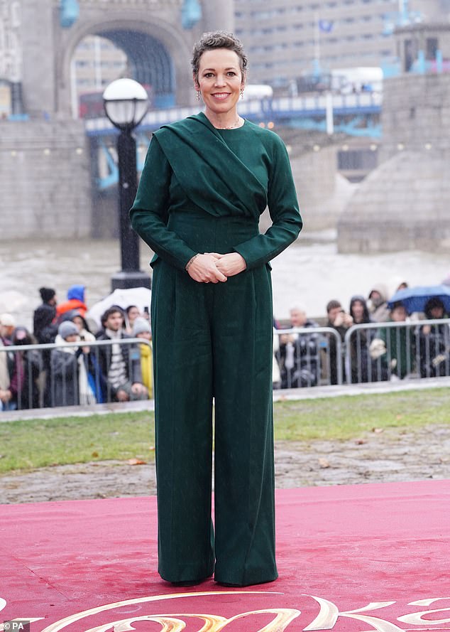 Glam: Olivia Colman looked chic in a dark green jumpsuit as she attended a photocall for Wonka at London's iconic Tower Bridge with her co-stars on Monday