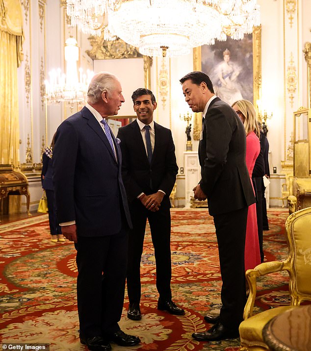 King Charles III (L) and British Prime Minister Rishi Sunak (C) speak with Nissan CEO Makoto Uchida (R) at Buckingham Palace to mark the closing of the Global Investment Summit yesterday